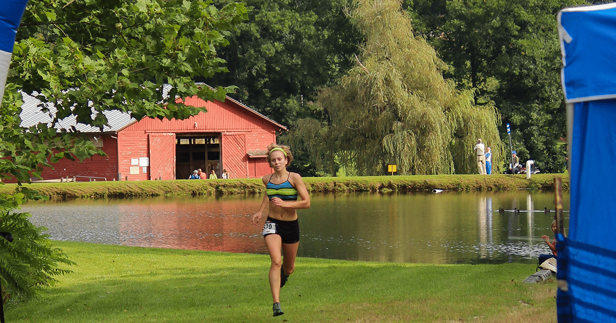 Female Trail Runner Crosses Finish Line Of Springmaid Splash at Springmaid Mountain in Spruce Pine, NC