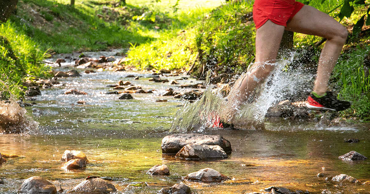 runner splashes through a creek tributary of the North Toe River at Springmaid Mountain